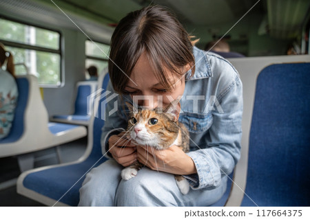 Excited woman and anxious nervous kitten traveling together, tripping riding on electric train Excited woman and anxious nervous kitten traveling together, tripping riding on electric train 117664375