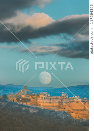 Jaipur, Rajasthan, India. Moon Rising Above Amer Fort Or Amber Fort, Amer, Rajasthan, India In sunset Time. Amer Palace Is Great Example Of Rajput Architecture. Amber Fort Principal Tourist Attraction 117664396