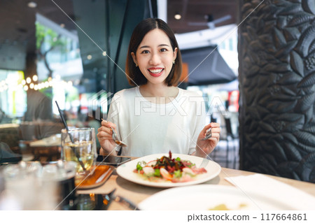 Asian woman eating healthy food at cafe restaurant city break on weekend lifestyles Asian woman eating healthy food at cafe restaurant city break on weekend lifestyles 117664861