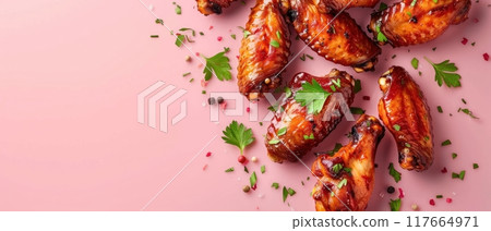 Close up of crispy chicken wings with herbs on pink background. 117664971