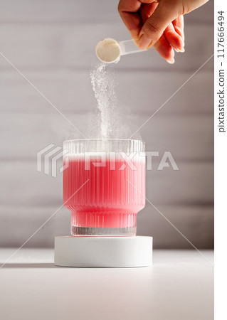 Collagen pink powder. Protein powder in a scoop. Food supplement 117666494