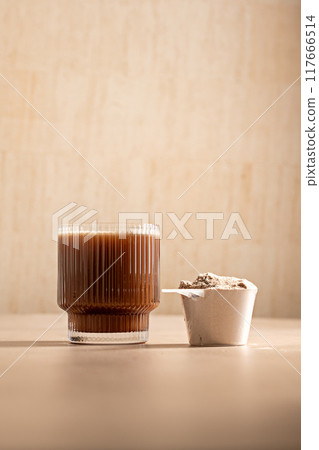 Chocolate protein powder in a measuring scoop. Nutrition and food supplement 117666514