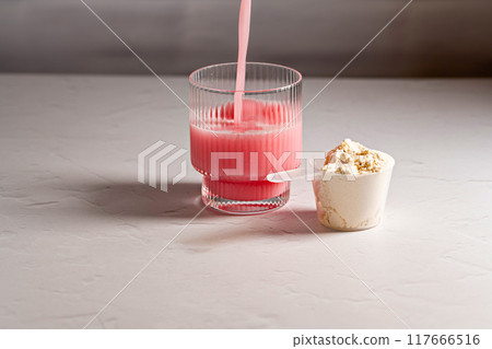 Collagen powder. Protein pink drink and powder in a scoop 117666516