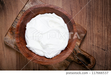 sour cream in a wooden bowl, on a wooden table, top view, close-up, no people, sour cream in a wooden bowl, on a wooden table, top view, close-up, no people, 117666537