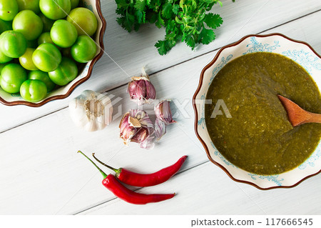 Tkemali sauce, traditional Georgian cuisine, green cherry plum, on a white wooden table, close-up, rustic, food background, no people, selective focus, 117666545