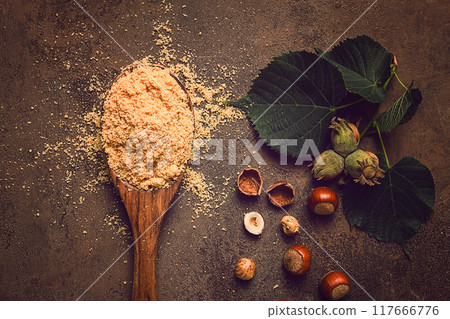 wooden spoon, with hazelnut flour, on a brown table, top view, no people, wooden spoon, with hazelnut flour, on a brown table, top view, no people, 117666776