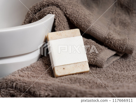 Beige soap bar with blank paper label on brown towels near vessel sink close up, mockup Beige soap bar with blank paper label on brown towels near vessel sink close up, mockup 117666911