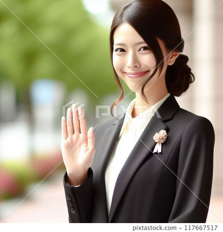 A woman raises her hand to greet an acquaintance who has arrived at the meeting place 117667517