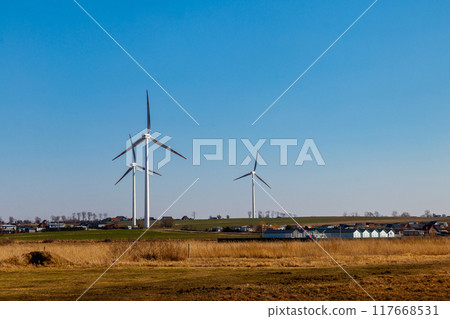 Wind turbines in a village. Renewable energy Wind turbines in a village. Renewable energy 117668531
