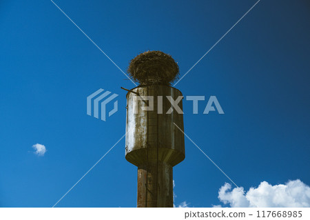 The stork's nest on the water tower. Clear sky. The clouds. Minimalism 117668985