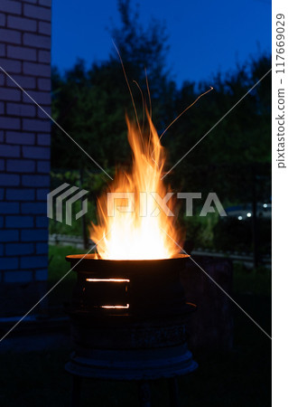 The fire is burning in the grill. A bonfire burning at night The fire is burning in the grill. A bonfire burning at night 117669029