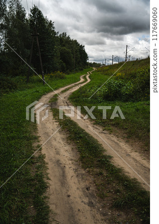 A rural, dirt road leading up. Cloudy sky A rural, dirt road leading up. Cloudy sky 117669060
