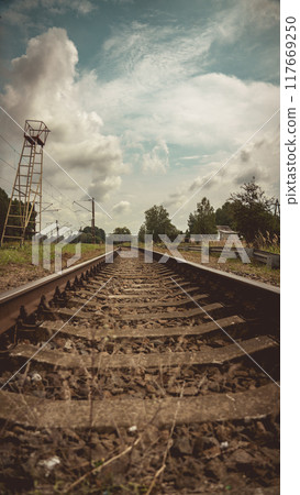 Railway tracks stretching away to the left. The railway going into the distance 117669250