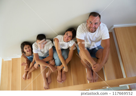 Family enjoying quality time together on indoor stairs at home 117669552