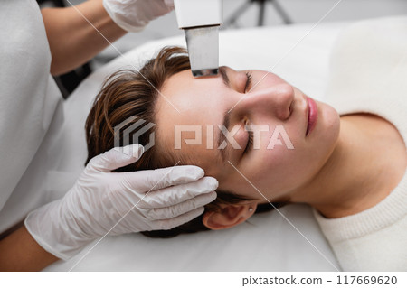 Ultrasonic cleaning of the face. Skin peeling. 117669620