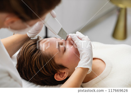 Woman receiving a skincare treatment in a beauty salon during the day 117669626