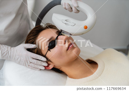 Woman receiving a facial treatment in a clinic during daylight hours Woman receiving a facial treatment in a clinic during daylight hours 117669634