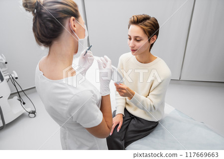 Woman consulting with a healthcare professional in a modern clinic during a beauty treatment Woman consulting with a healthcare professional in a modern clinic during a beauty treatment 117669663
