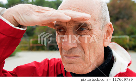 Fisherman Staring At The Sea With Hands To Cover From Sunlight  117669789