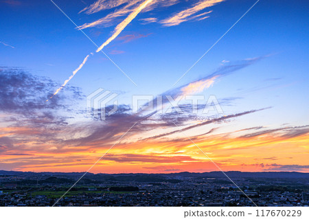 Evening view from Shiroyamadai in Kizugawa City, the southernmost part of Kyoto Prefecture. A sunset sky with contrails crossing the sky. #13 117670229