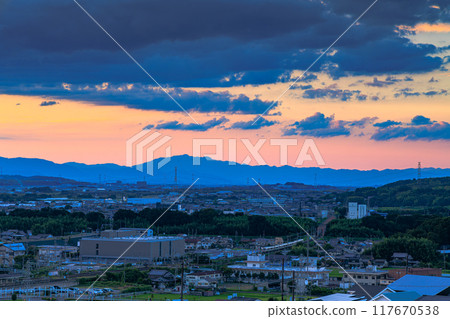 京都府最南端木津川市城山台的夜景，夕陽下的天空上空烏雲密布，JR 奈良線 2 號列車穿過木津川鐵橋。 117670538