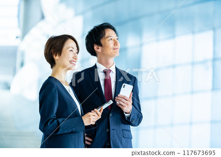 Male and female employees with smartphones Business image Male and female employees with smartphones Business image 117673695