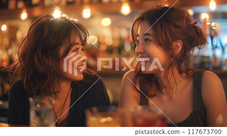 Japanese women enjoying conversation at a cafe bar at night 117673700