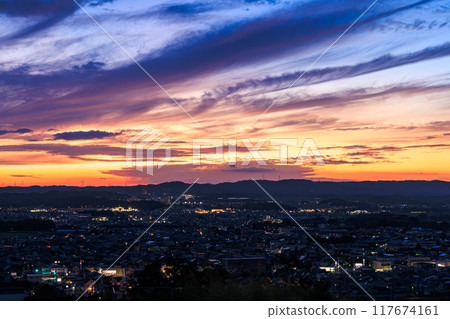 Evening view from Shiroyamadai in Kizugawa City, the southernmost part of Kyoto Prefecture. The sky turns deep blue and the sunset on the mountainside. On a hill overlooking the town of Kizu #14 117674161
