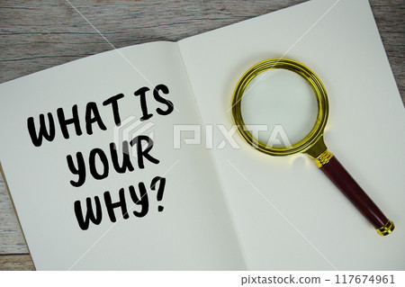 What is your why? text on notebook page with magnifying glass top view on wooden background What is your why? text on notebook page with magnifying glass top view on wooden background 117674961