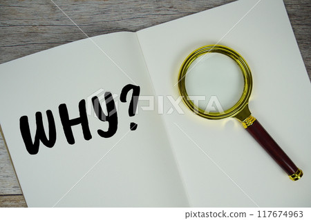 Why? text on notebook page with magnifying glass top view on wooden background Why? text on notebook page with magnifying glass top view on wooden background 117674963