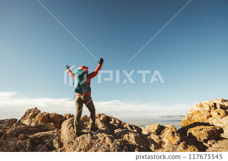 Woman hiker enjoy the view on mountain top cliff edge at lakeside 117675545
