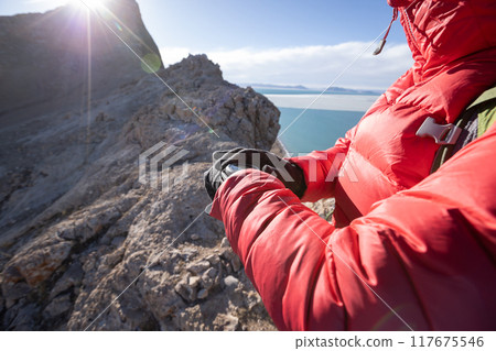 Hiker on high altitude mountain top checking the altimeter on the sports watch 117675546