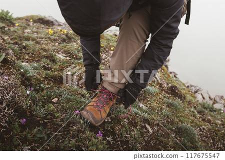 Successful woman hiker tying shoelace at mountain top in tibet 117675547