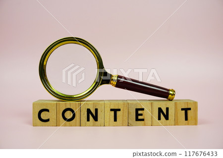 Content with wooden blocks alphabet letters and Magnifying glass on pink background 117676433