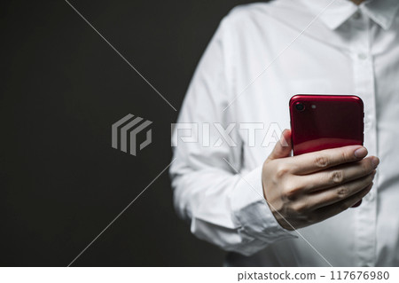 Black background Woman holding a smartphone Black background Woman holding a smartphone 117676980