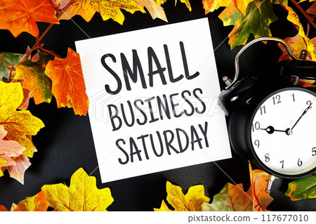 Small Business Saturday text with alarm clock and maple leaf decoration on wooden background Small Business Saturday text with alarm clock and maple leaf decoration on wooden background 117677010
