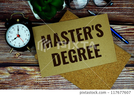 Master's Degree text on paper card with alarm clock top view on wooden background, Education concept Master's Degree text on paper card with alarm clock top view on wooden background, Education concept 117677607