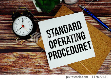 Standard Operating Procedure text written on paper card with alarm clock top view 117677610
