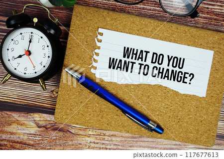 What do you want to change? text written on paper torn with pen top view on wooden background What do you want to change? text written on paper torn with pen top view on wooden background 117677613