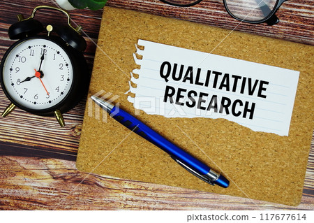 Qualitative Research text written on paper torn with alarm clock top view 117677614