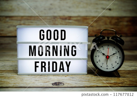 Good Morning Friday text on LED lightbox with alarm clock on wooden background 117677812