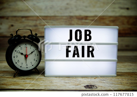 Job Fair text on LED lightbox with alarm clock on wooden background Job Fair text on LED lightbox with alarm clock on wooden background 117677815