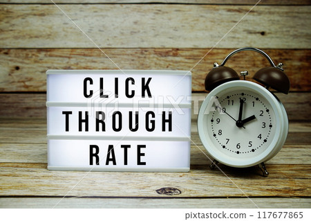 Click through rate text on LED lightbox with alarm clock on wooden background, Business and Money concept Click through rate text on LED lightbox with alarm clock on wooden background, Business and Money concept 117677865