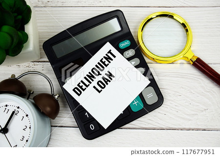 Delinquent Loan text message with calculate, alarm clock and magnifying glass on wooden background Delinquent Loan text message with calculate, alarm clock and magnifying glass on wooden background 117677951