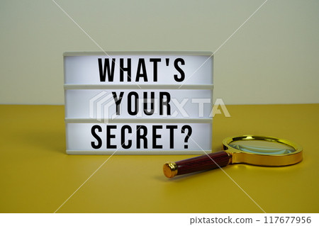 What's Your Secret? text on LED lightbox with magnifying glass on yellow background What's Your Secret? text on LED lightbox with magnifying glass on yellow background 117677956