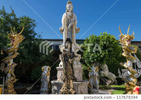 Quan Yin Shrine and gold dragon statues in park at wat Khoi, hetchaburi Quan Yin Shrine and gold dragon statues in park at wat Khoi, hetchaburi 117678394