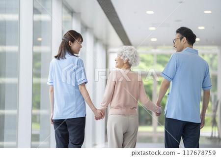 高級婦女和護理人員手牽手行走，後視 117678759
