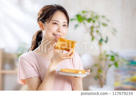 Young woman eating toast 117679239