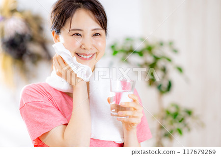 Young woman drinking water in the room 117679269