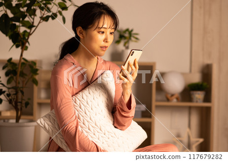 晚上看智慧型手機的年輕女子 117679282